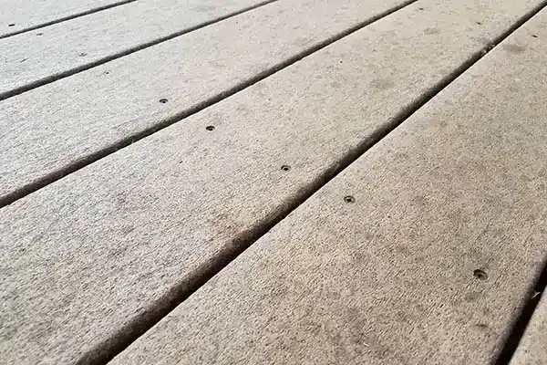 Close up shot of uncapped composite deck boards showing signs of fading.